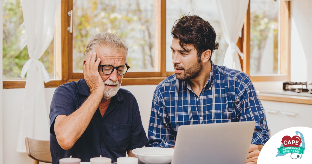 A man looks at a computer with his father who is confused, representing one of the early signs of dementia.