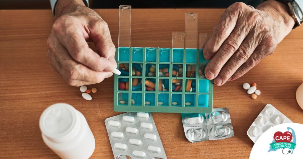 Older hands organize pills into a pill organizer, showing a great tool for managing medications.