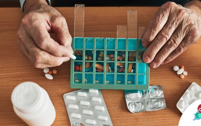 Older hands organize pills into a pill organizer, showing a great tool for managing medications.